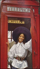 Fashion setting in Telephone kiost featuring a purple Biba hat