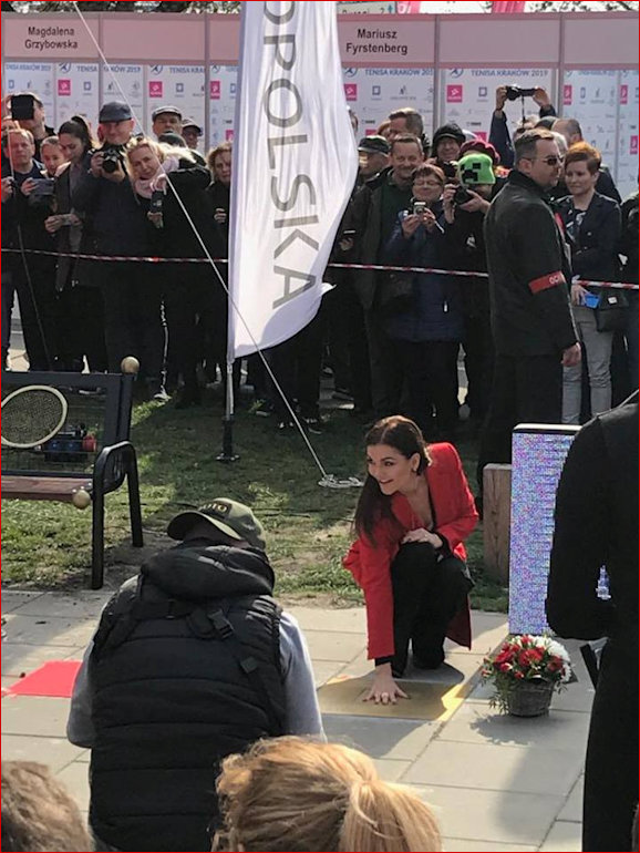 Aga kneeling by her handprint plaque