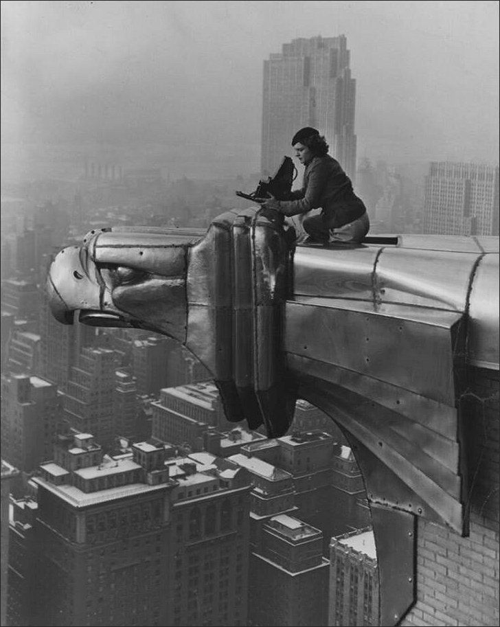 American photographer and journalist Margaret Bourke-White perches on an eagle head gargoyle at the top of the Chrysler building