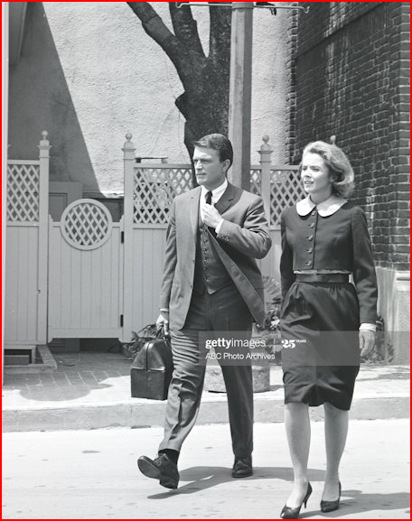 Mike and Laura striding past the white picket fence
